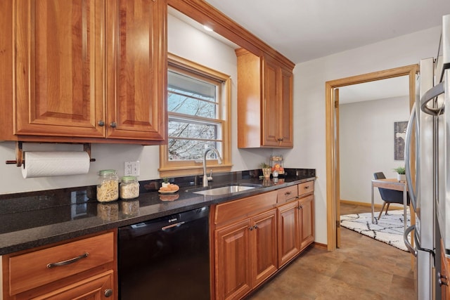 kitchen featuring black dishwasher, brown cabinets, freestanding refrigerator, and a sink