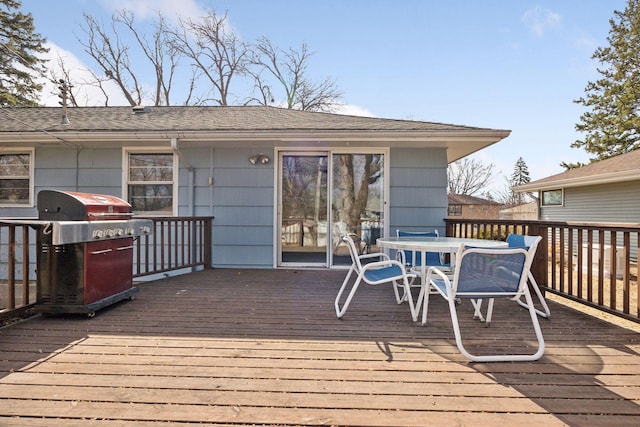 deck with outdoor dining space and a grill