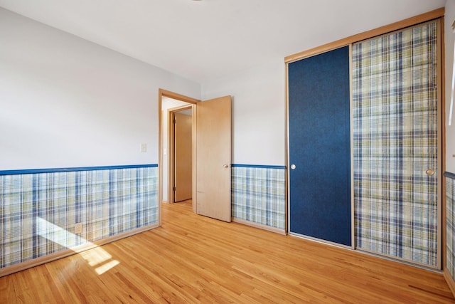 spare room with wood finished floors and wainscoting