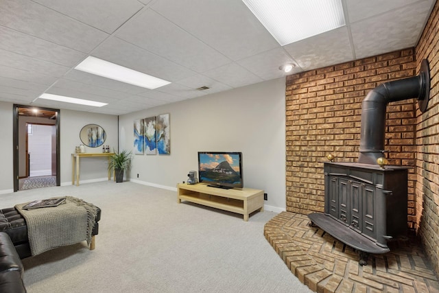 carpeted bedroom featuring a drop ceiling, baseboards, a wood stove, and visible vents