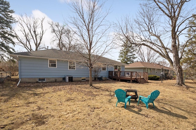 back of property featuring a wooden deck, cooling unit, an outdoor fire pit, and a shingled roof