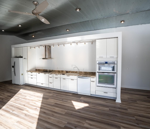 kitchen featuring dark wood-type flooring, white appliances, white cabinets, and wall chimney exhaust hood