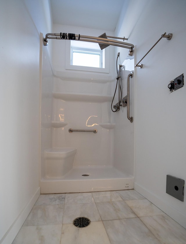 bathroom with tile patterned floors, baseboards, and walk in shower