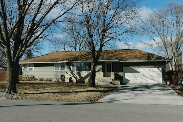 ranch-style house featuring a garage, concrete driveway, and fence