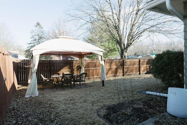 view of jungle gym featuring a gazebo, outdoor dining space, and a fenced backyard