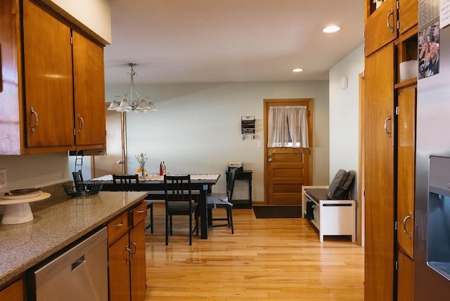 kitchen with recessed lighting, light wood-style floors, stainless steel dishwasher, brown cabinetry, and an inviting chandelier