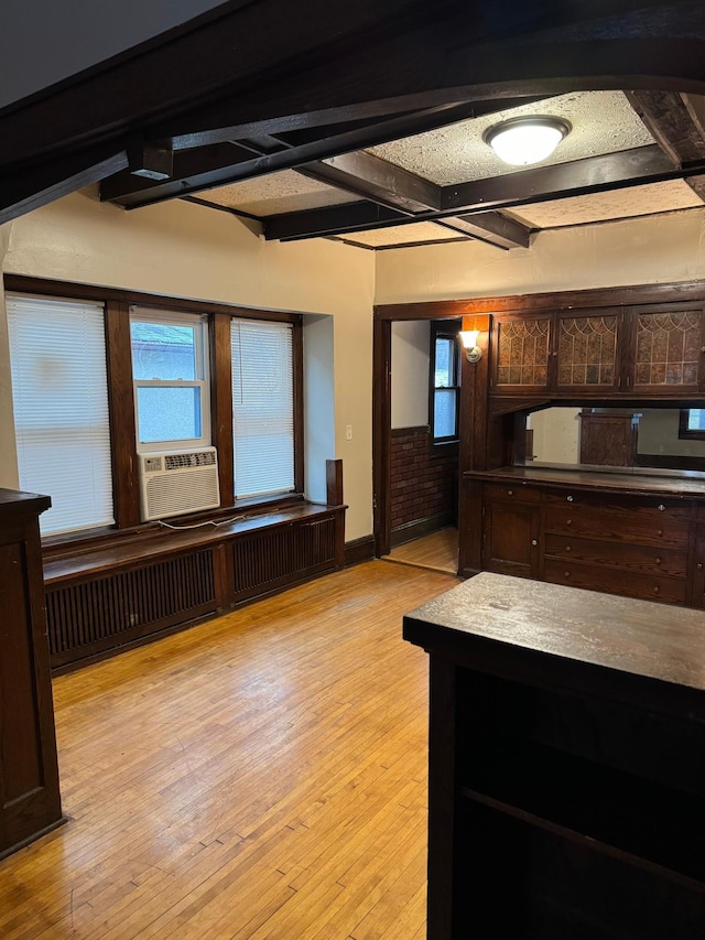 kitchen with dark brown cabinetry, radiator heating unit, beamed ceiling, cooling unit, and light wood-style floors