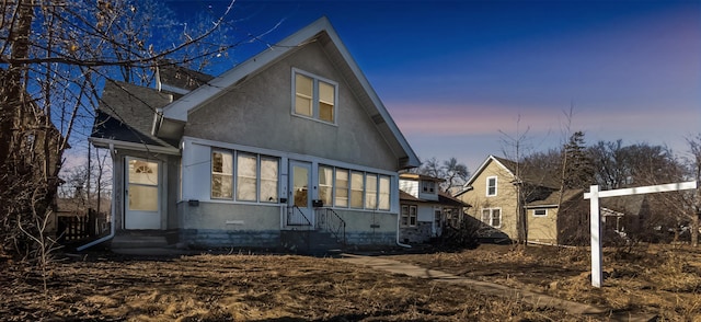 view of front of home with entry steps and a shingled roof