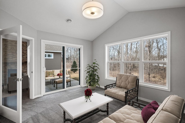 carpeted living area with visible vents, french doors, baseboards, and vaulted ceiling