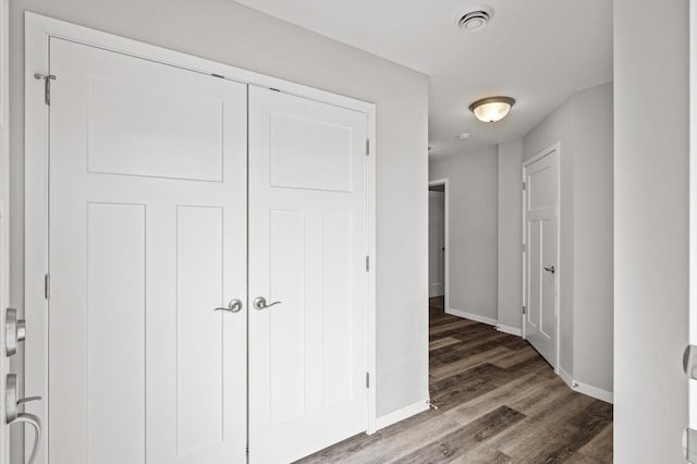 interior space with a closet, visible vents, baseboards, and wood finished floors