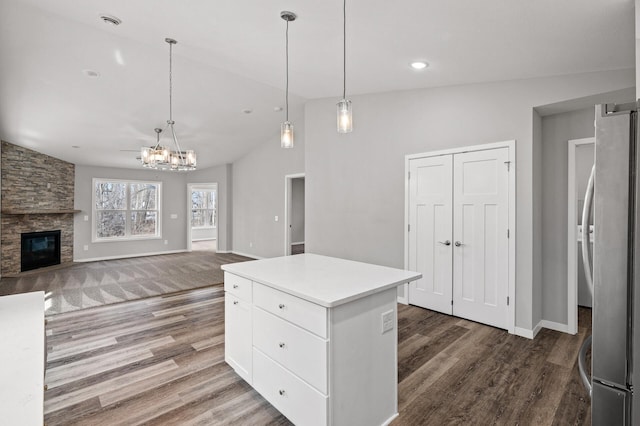 kitchen featuring a stone fireplace, wood finished floors, white cabinetry, and freestanding refrigerator