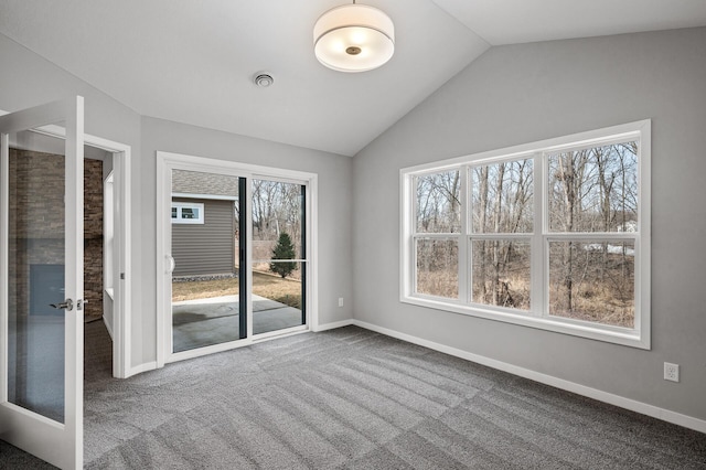 empty room featuring visible vents, baseboards, carpet flooring, and vaulted ceiling