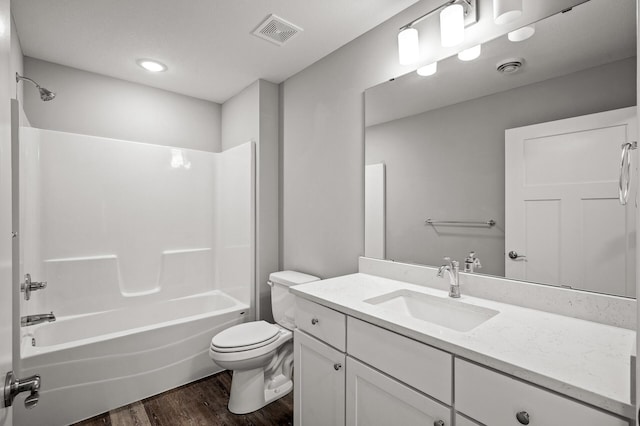 bathroom with visible vents, toilet, wood finished floors, and shower / tub combination