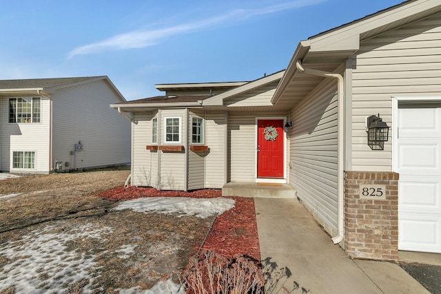 view of exterior entry featuring an attached garage