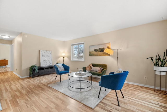 living area featuring baseboards and wood finished floors