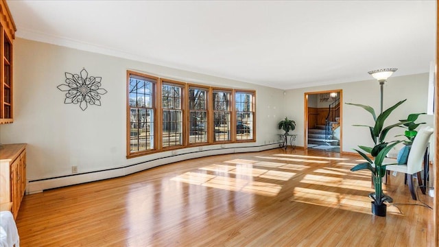 living area featuring a baseboard radiator, stairway, wood finished floors, and ornamental molding