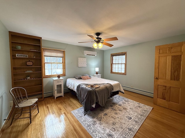 bedroom featuring light wood finished floors, an AC wall unit, a ceiling fan, and a baseboard radiator