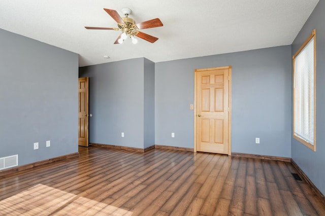 unfurnished room with visible vents, baseboards, and wood finished floors