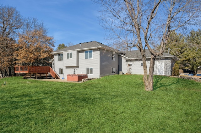 back of house with a deck, a lawn, and a hot tub