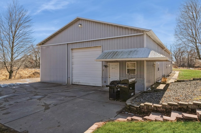 view of front of property featuring driveway, a garage, and an outbuilding