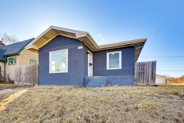 view of front of property featuring fence and stucco siding