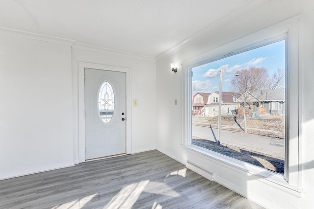 foyer featuring baseboards, crown molding, and wood finished floors