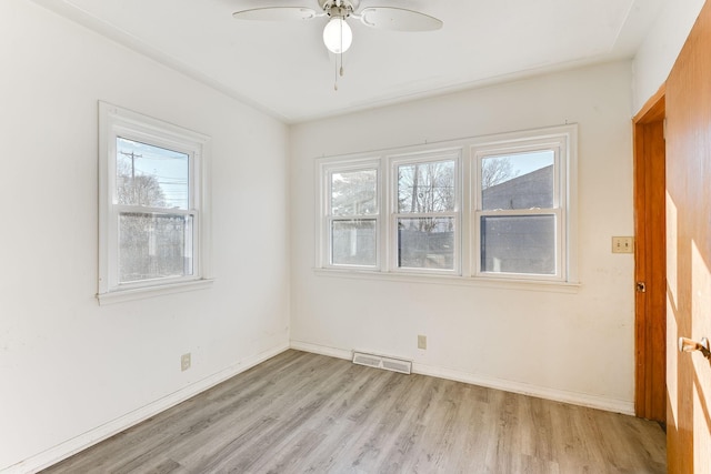 unfurnished room featuring light wood-type flooring, visible vents, ceiling fan, and baseboards