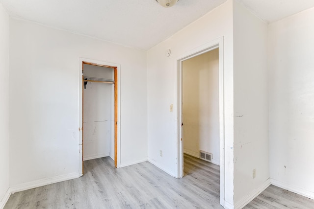 unfurnished bedroom with light wood finished floors, visible vents, and baseboards