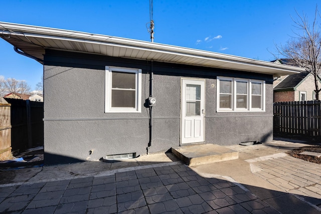 back of house featuring fence and stucco siding