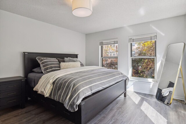 bedroom featuring a textured ceiling and dark wood-type flooring