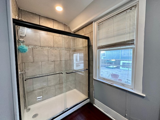 full bathroom featuring tiled shower and baseboards