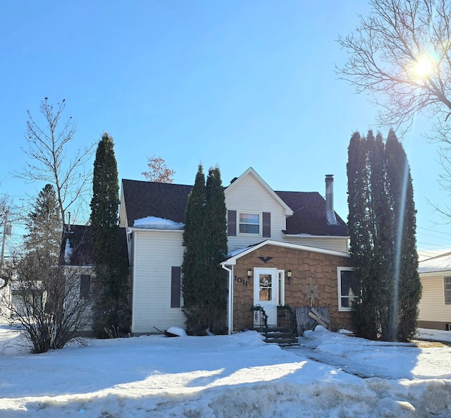 view of front of property with a shingled roof and stone siding