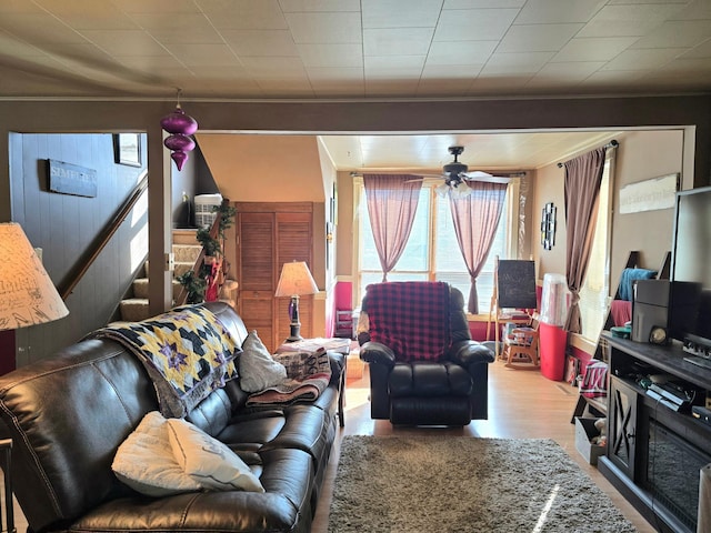 living area with ceiling fan, stairway, and light wood-style floors