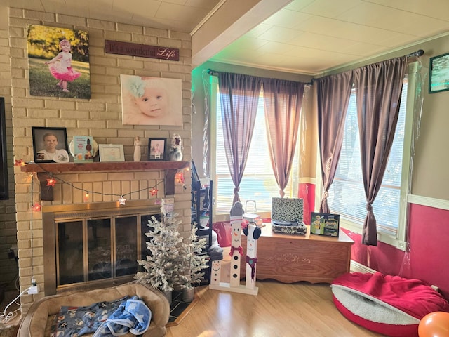 interior space with a brick fireplace, wood finished floors, and a wealth of natural light