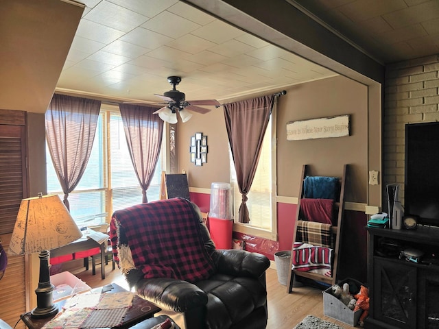 sitting room featuring ornamental molding, ceiling fan, and light wood finished floors