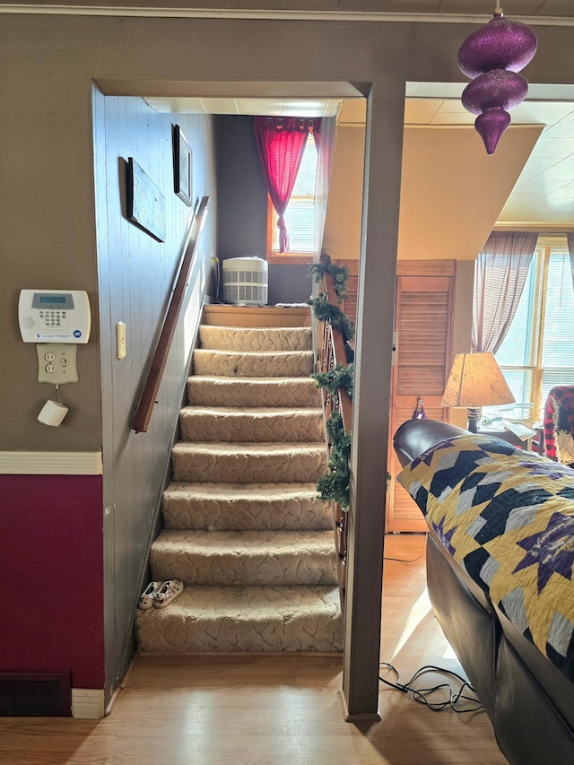 staircase with wood finished floors, visible vents, and baseboards