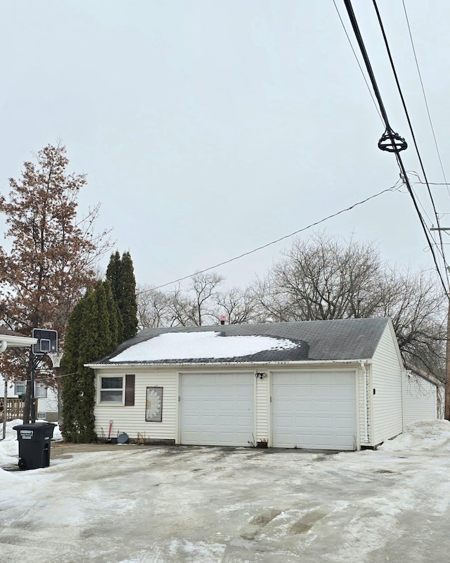 snow covered garage featuring a garage