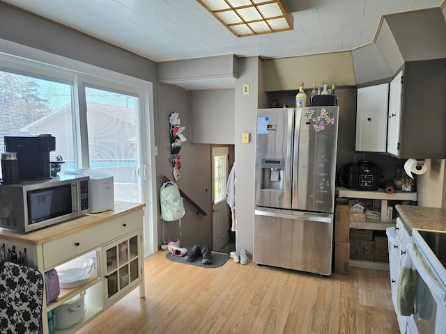 kitchen featuring stainless steel appliances, light wood-style flooring, and white cabinetry