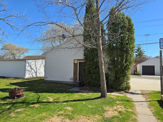 view of front of home with a fire pit, an outdoor structure, and a front lawn