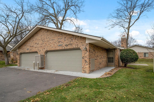 view of property exterior featuring an attached garage, a yard, a chimney, and brick siding