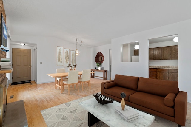 living area featuring light wood-style flooring and vaulted ceiling