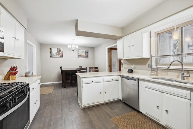 kitchen with pendant lighting, light countertops, a sink, and stainless steel dishwasher