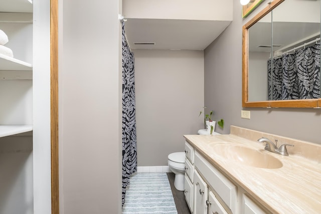 bathroom featuring toilet, visible vents, vanity, and baseboards