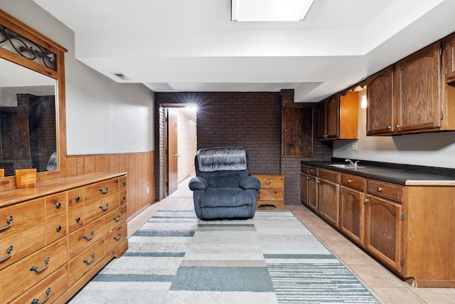 interior space with a wainscoted wall, wood walls, visible vents, and light tile patterned floors