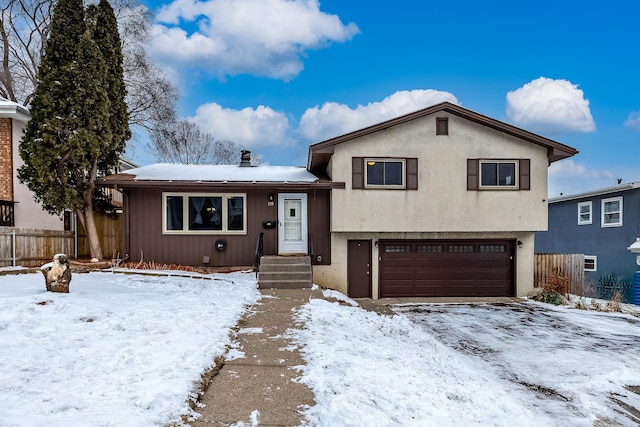 split level home featuring an attached garage and fence