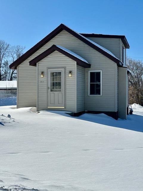 view of snow covered back of property