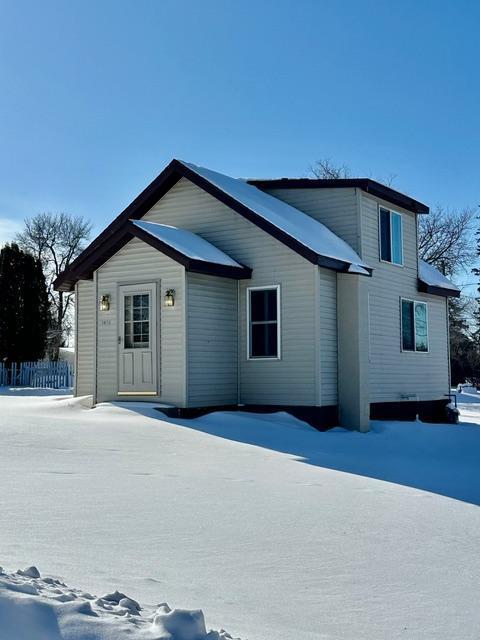 view of snow covered back of property