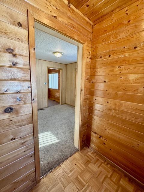 corridor featuring wood walls