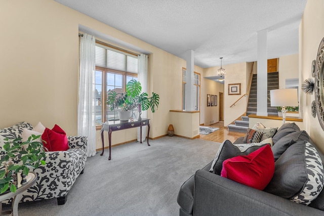 carpeted living room with stairs, baseboards, and a textured ceiling