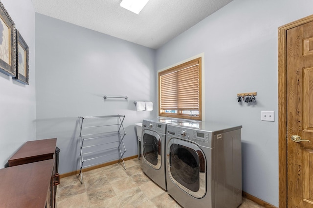 laundry room with baseboards, a textured ceiling, independent washer and dryer, and laundry area